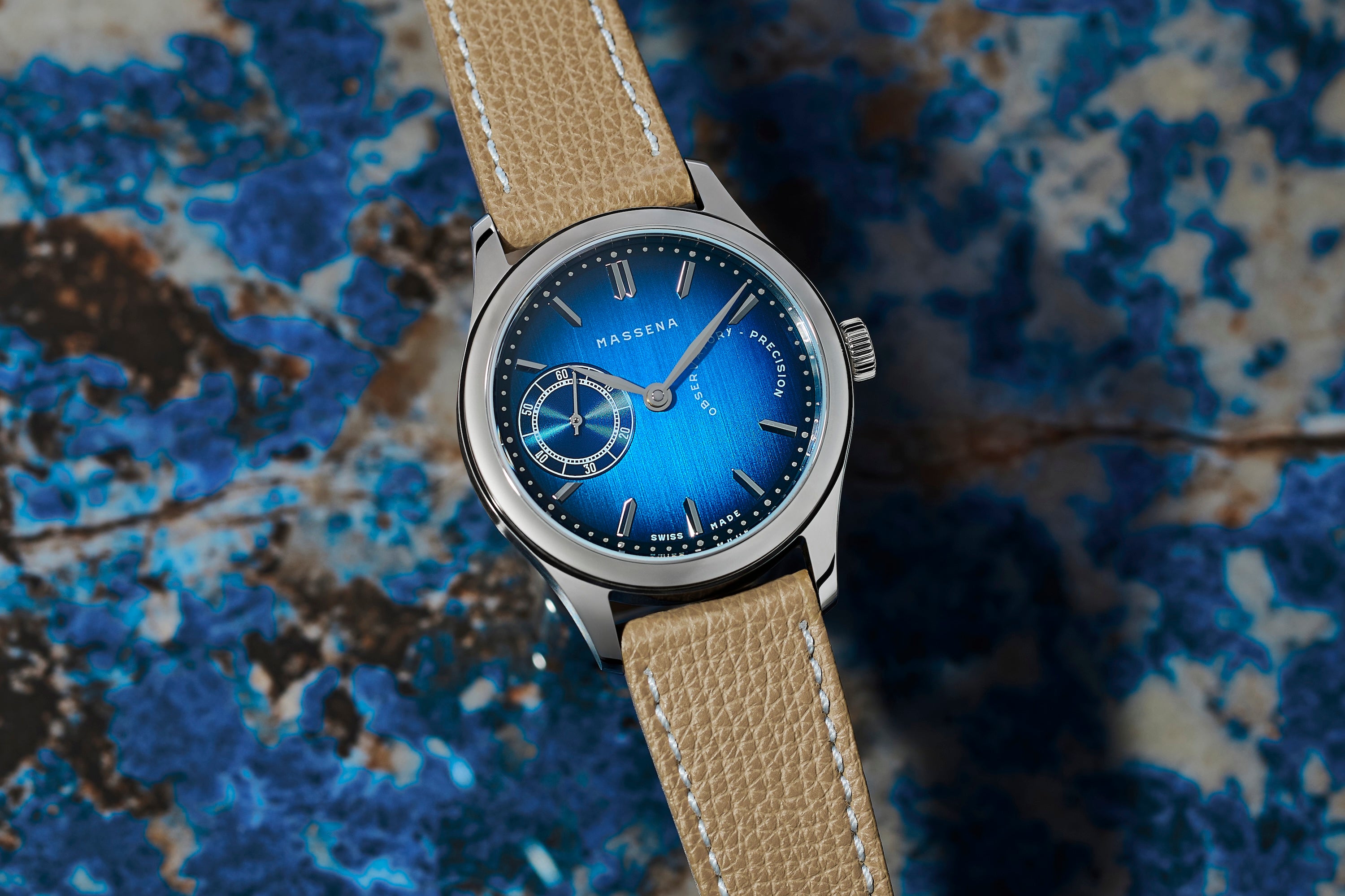 The TZ30 by Massena LAB and Raúl Pagès limited edition wristwatch shown on a blue stone background.