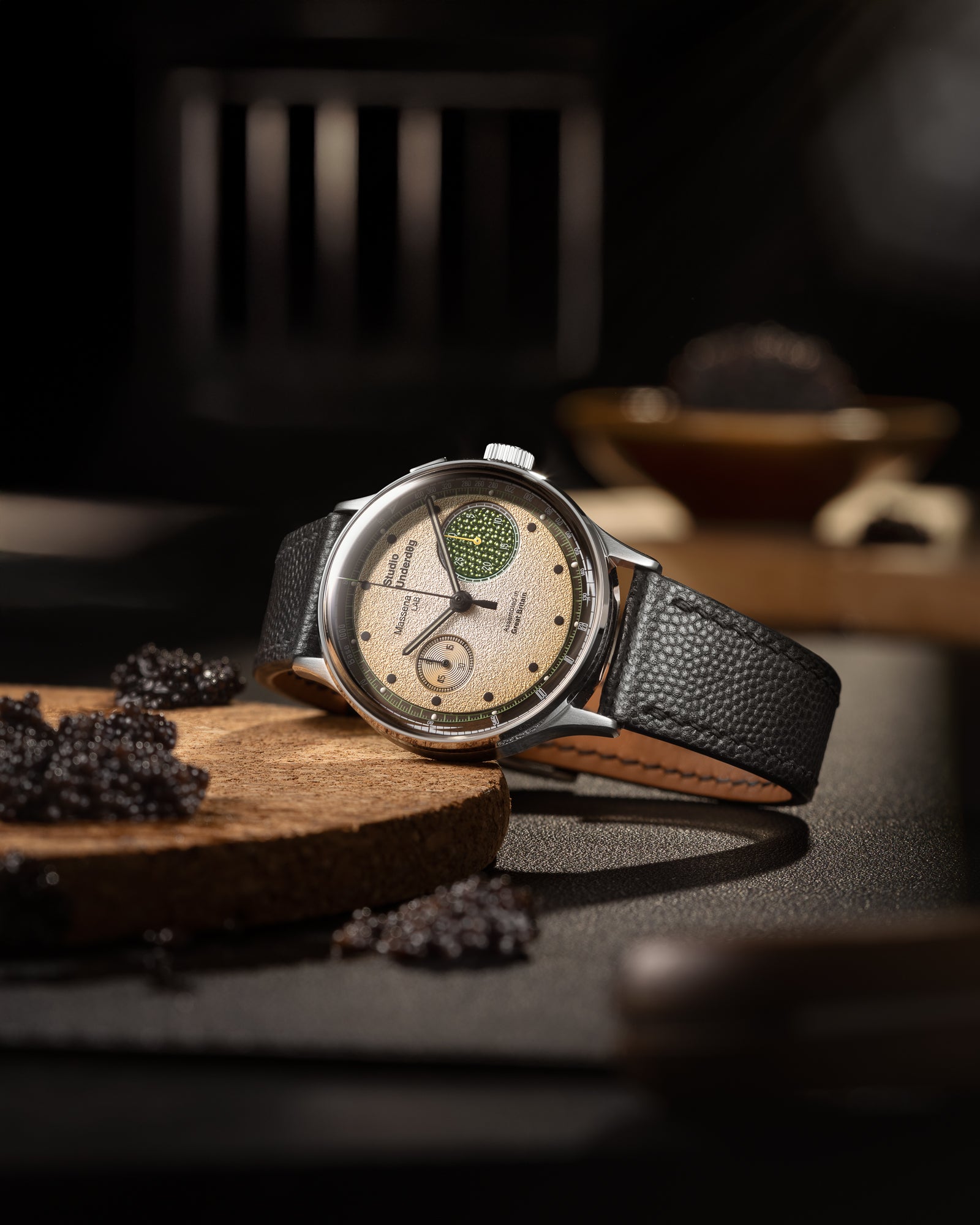 Studio Underd0g x Massena LAB Champagne & Caviar Monopusher Chronograph Limited Edition shown on its side with caviar in the background.